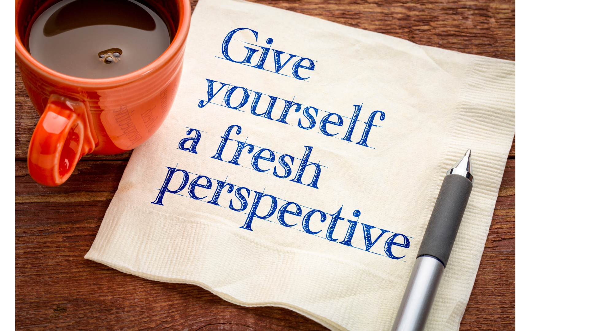A cup of coffee Next to it a napkin with text: give yourself a fresh perspective